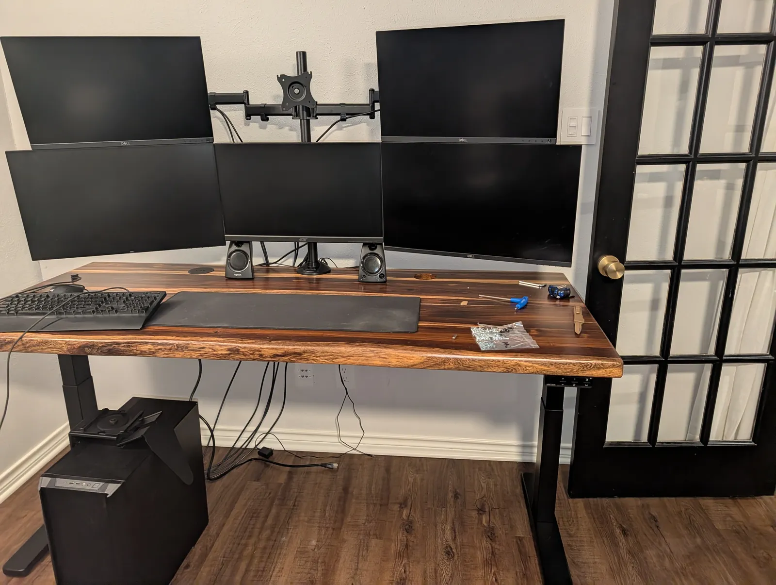 Screens going up on the Moontower arm for the first time, keyboard and desk pad already on the Pheasantwood top, cables still running loose to the floor.