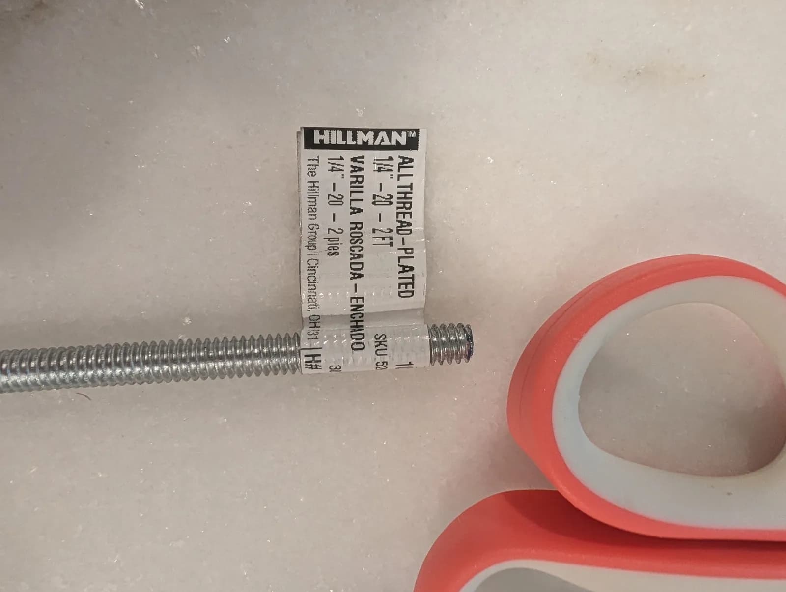 A Hillman quarter-inch-twenty all-thread rod still in its hardware-store label, bought to replace the CPU holder's stock rod.
