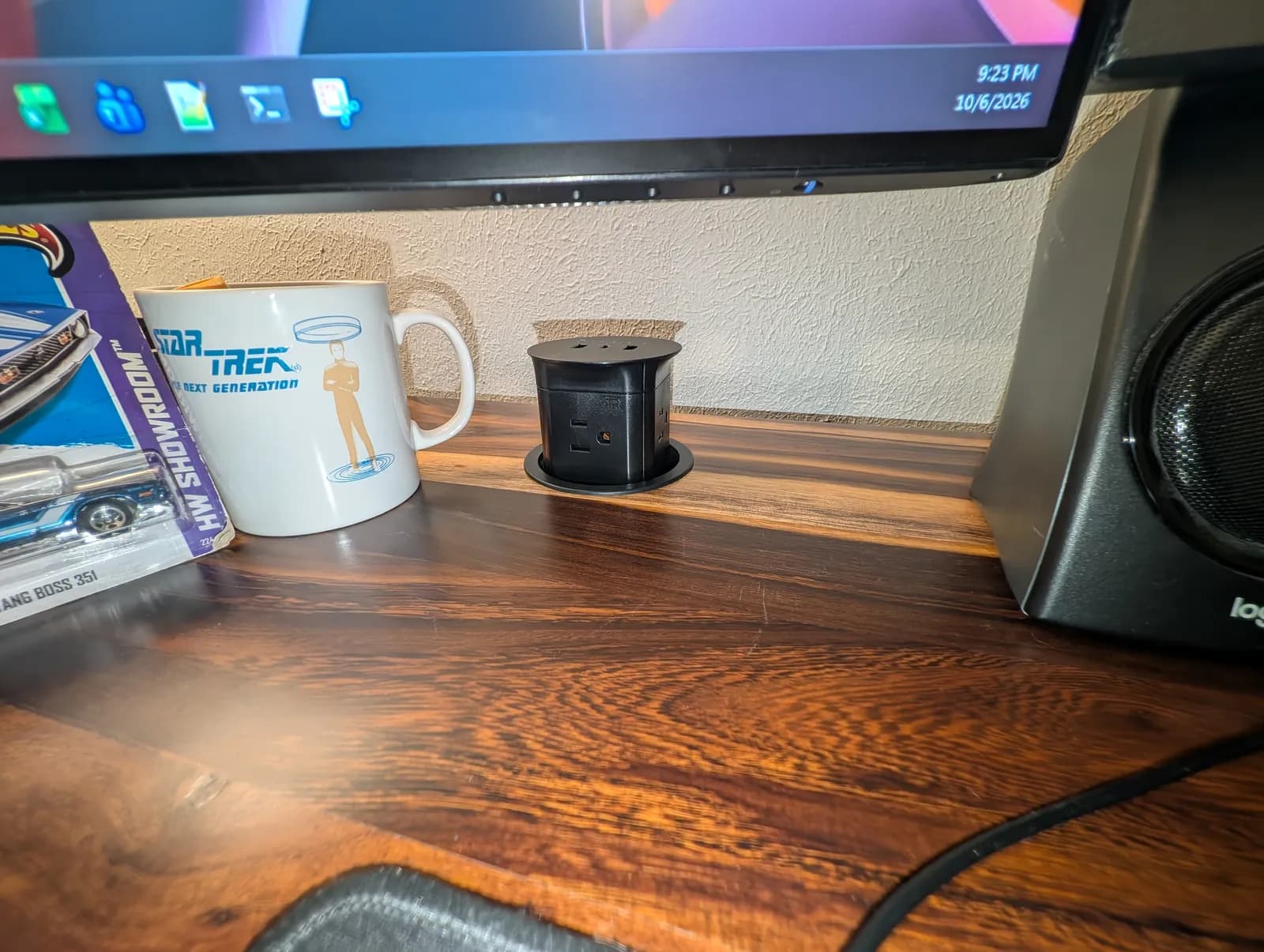 The same grommet popped up, standing proud of the desktop and showing the outlets and USB ports around its rim.